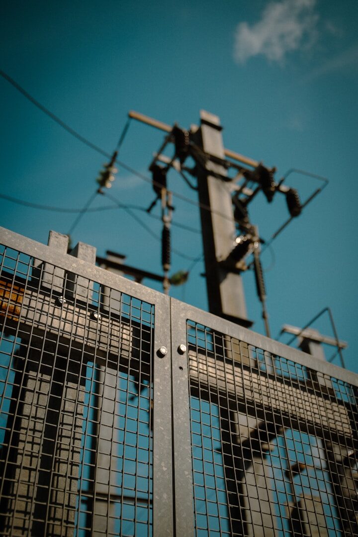a close up of a metal gate with a sky background